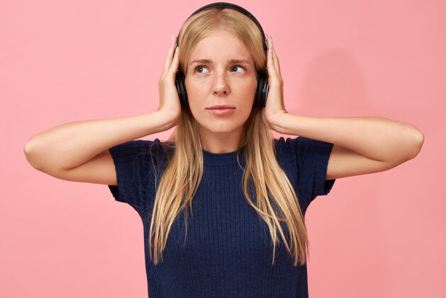 时尚一个可爱的少女手放在耳朵上 用无线耳机在mp3播放器中欣赏高品质音乐的孤立镜头女人放松耳机