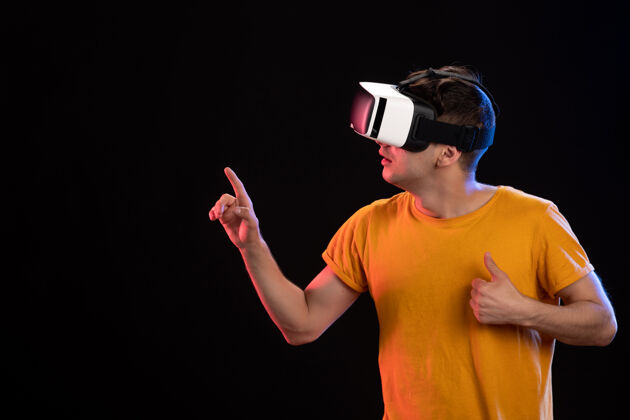 虚拟戴着虚拟现实耳机的年轻人肖像黑暗视觉游戏d穿着通信游戏