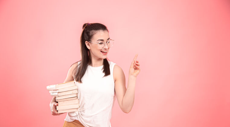 表情一个戴眼镜的女学生的画像 手里拿着书教育和爱好的概念女孩聪明书籍