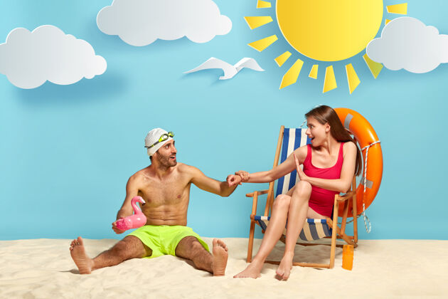 高兴有趣快乐的男性度假者坐在温暖的沙滩上积极休闲坐着