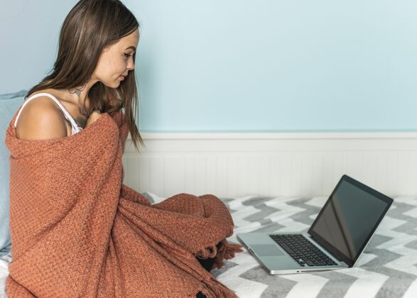 女性大流行期间 家里穿着毛毯的妇女在笔记本电脑上工作病毒女性冠状病毒