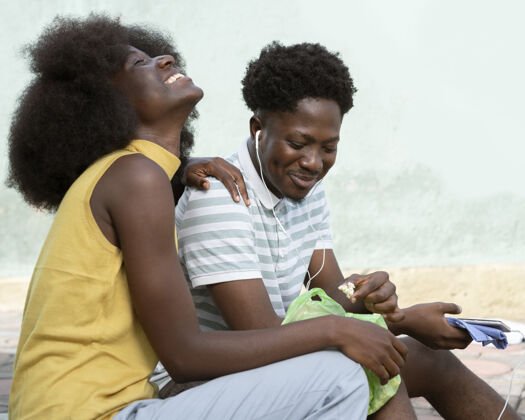 男人微笑的女人和男人听音乐非洲成人村庄