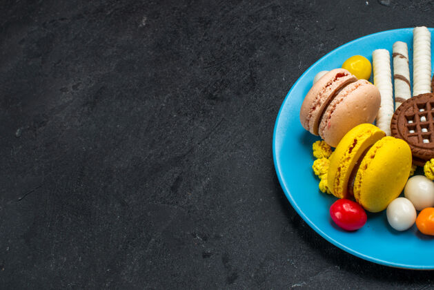 饼干前视图美味的法国马卡龙糖果和巧克力饼干在灰色办公桌饼干糖蛋糕甜烤饼干视图马卡龙饼干