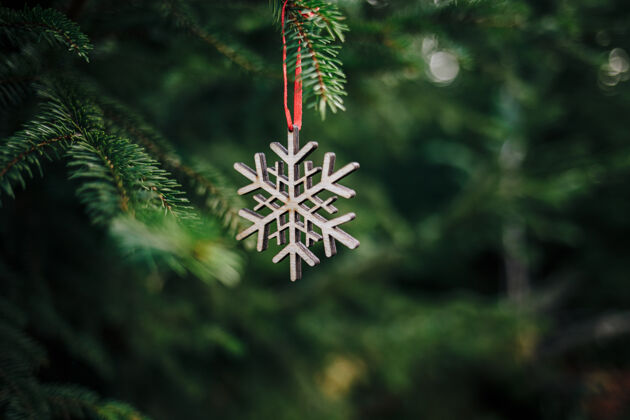 背景特写一个木制雪花形状的圣诞装饰品在松树上小雪花年