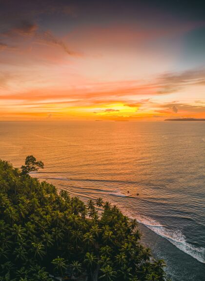 云印尼日落时分 静谧的海洋和岸边树木的迷人景色印度尼西亚海滩沙滩