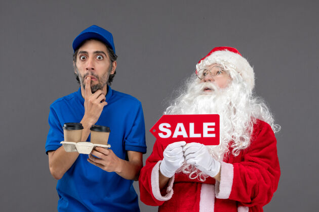 十二月圣诞老人的正面图 男信使拿着售货笔 灰色墙上挂着咖啡人举行男