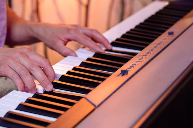 背景男性手在一个美丽的彩色背景钢琴键特写音乐特写手