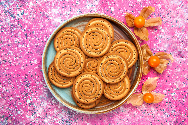 黄金粉红色表面盘子里甜饼的俯视图糖果糖果装饰