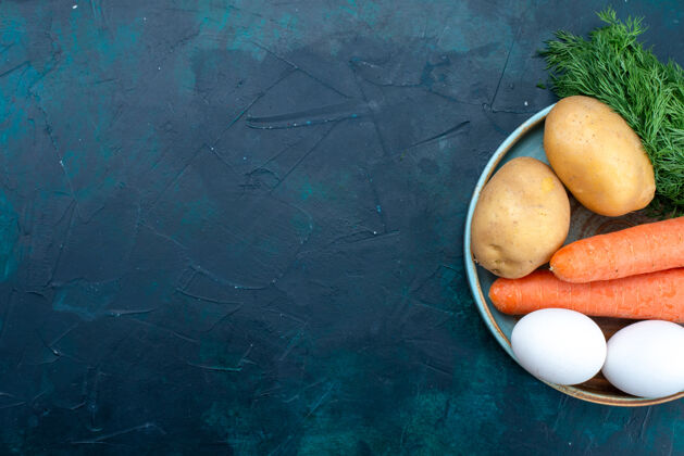 土豆在深蓝色的桌子上俯瞰胡萝卜和土豆 还有鸡蛋和蔬菜蔬菜新鲜绿色
