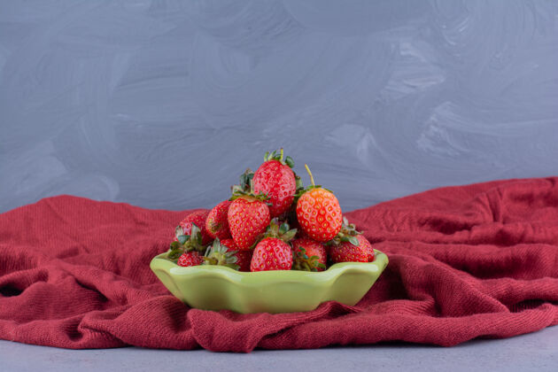 碗一小碗草莓嵌套在大理石背景上一堆起皱的桌布上水果可口美味