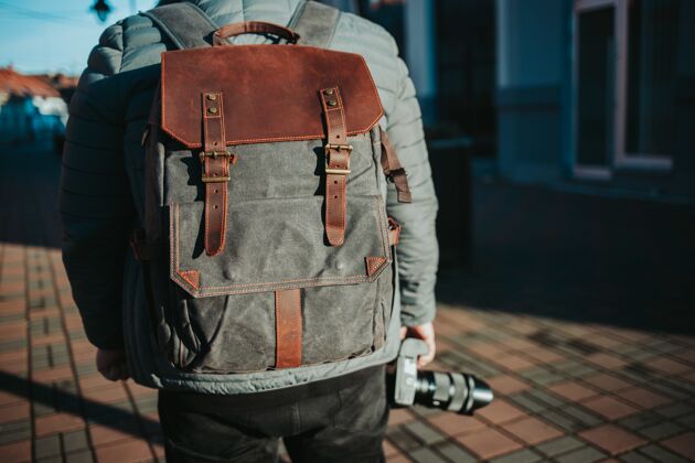 包浅焦拍摄一个男性穿着灰色和棕色背包旅行街道皮革