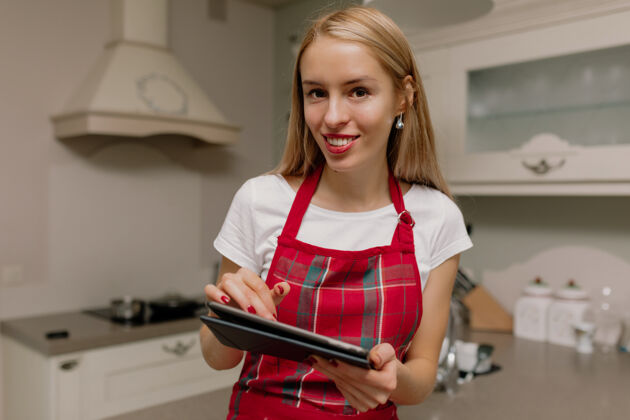 平板电脑厨房里拿着写字板的女人烹饪厨房女人