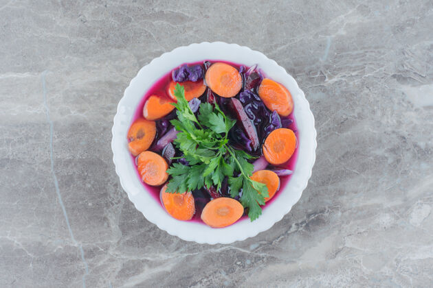 甜菜膳食沙拉混合甜菜 胡萝卜片和欧芹装饰在大理石碗顶部碗农产品