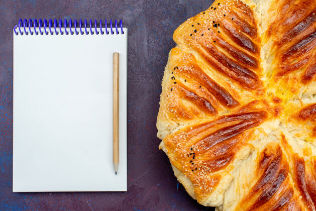 面包顶视图美味糕点烤面包形成糕点与记事本上的黑暗背景美味盘子小面包
