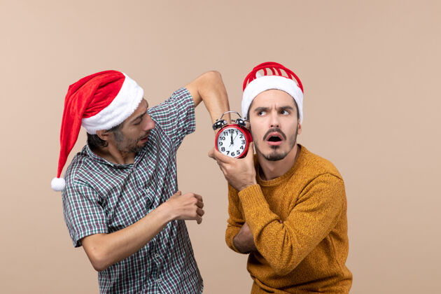 帽子正面图两个男人一个拿着闹钟 背景是米色的男人两个闹钟