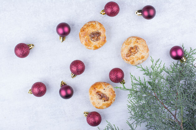 小吃核桃饼干和闪闪发光的圣诞球美味甜食树枝