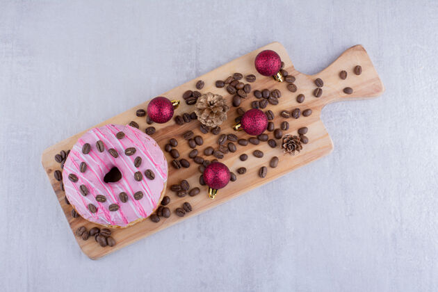 美味小木托盘 白色背景上有甜甜圈 咖啡豆 松果和圣诞装饰品开胃上釉豆子