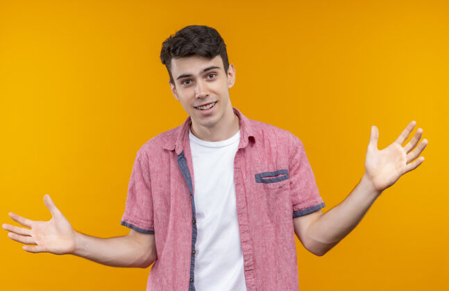 年轻微笑着的白人年轻人穿着粉色衬衫 在孤立的橙色背景上展示身材衬衫展示微笑