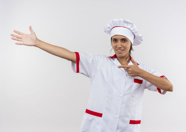 手面带微笑的年轻女厨师穿着厨师制服 用手和手指指向一边手指厨师厨师