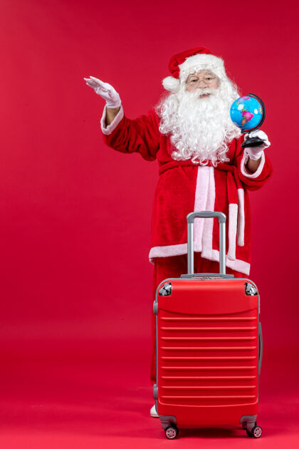 前面红墙上准备旅行的圣诞老人的前视图圣诞老人旅行冬天