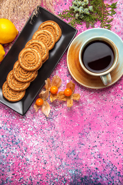 糖浅粉色桌上放着一杯茶 上面放着饼干和柠檬柠檬棕色饼干