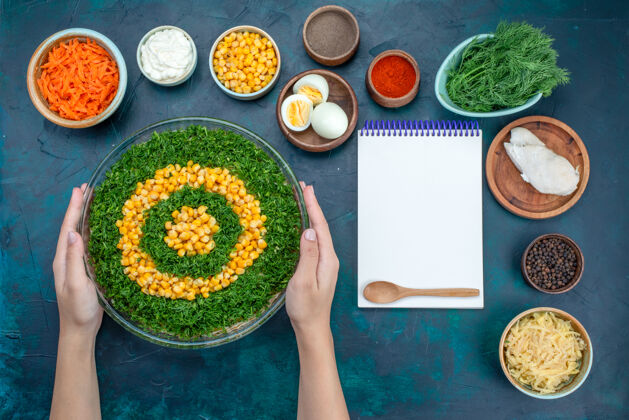托盘在深蓝色的桌子上 可以看到蔬菜沙拉 玉米 胡萝卜片和鸡蛋盘子绿色蔬菜