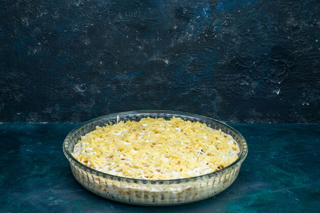 谷类在深蓝色的桌子上可以看到美味的沙拉和蛋黄酱蔬菜和奶酪前面深色奶酪