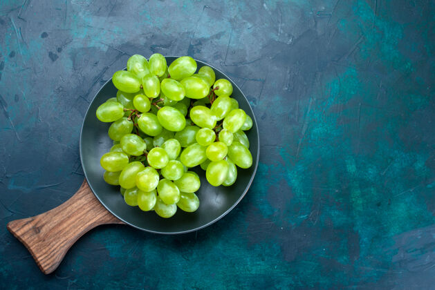 食物顶视图新鲜的绿色葡萄醇厚多汁的水果在深蓝色的背景板内葡萄绿色水果