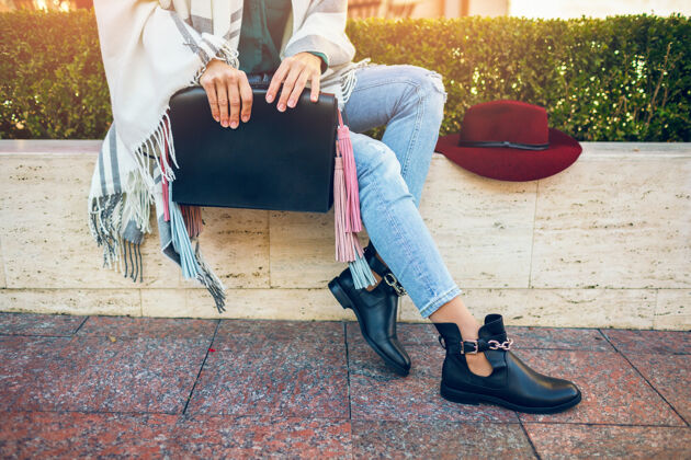 帽子特写的女人腿穿黑色皮靴 牛仔裤 鞋春季潮流 手袋装装户外包