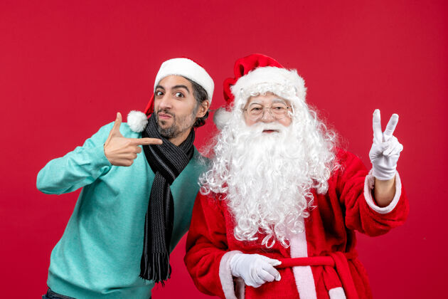 快乐正面图：圣诞老人和年轻的男性站在一起帽子圣诞人