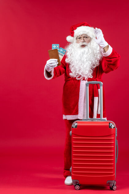 庆祝圣诞老人的前视图 带着包 拿着票 准备在红墙上旅行圣诞快乐圣诞老人快乐
