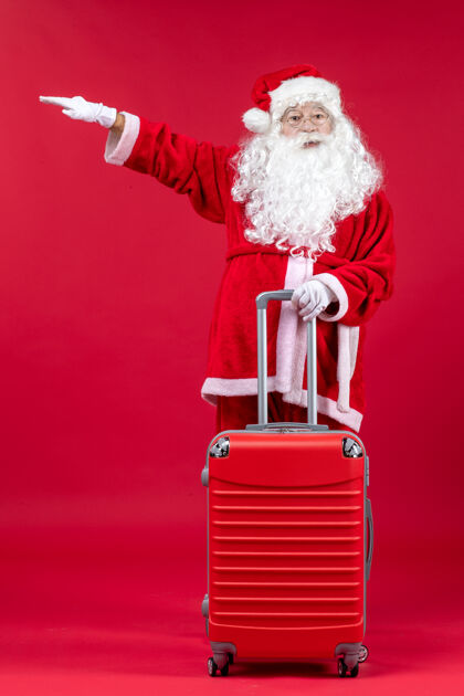 快乐圣诞老人的正面图 红色的墙上挂着他的红色袋子前面人庆祝