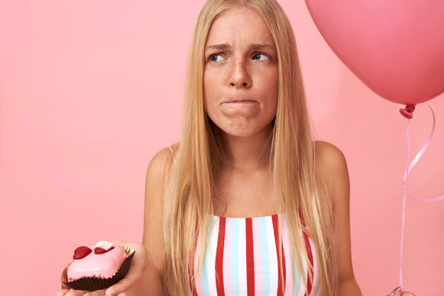 卡路里可爱的情绪化的欧洲年轻女子的画像氦气球正在严格节食优柔寡断沮丧的表情 想吃甜的碳水化合物甜点积极嘴巴悲伤
