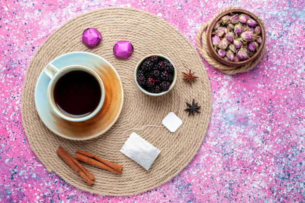 茶顶视图一杯茶 粉色背景上有糖果和肉桂糖果邦邦巧克力