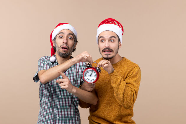脸正面图两个男人都拿着红色的钟 背景是米色的两个男人肖像