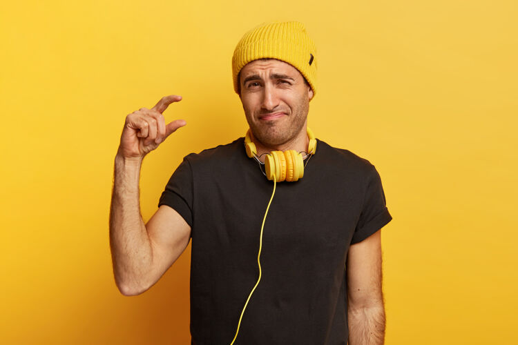 手心烦意乱的年轻人用手指展示身材矮小 展示身材瘦小 笑脸 诉说销量下降最小不高兴音乐