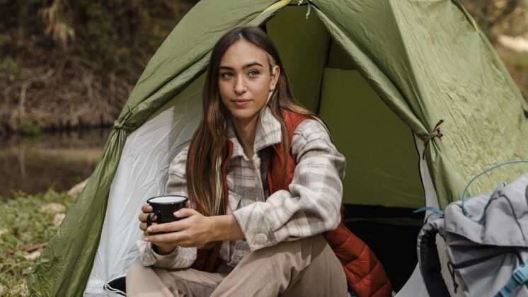 探险森林里的野营女孩拿着一个杯子森林度假旅行