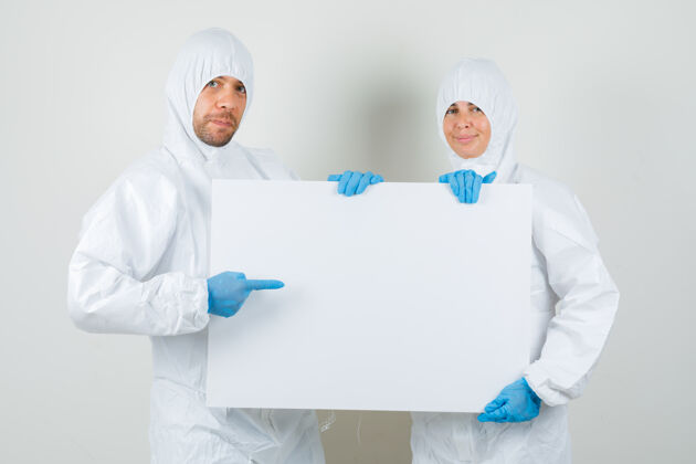 谈话两个穿着防护服指着空白帆布的医生现代男人画布