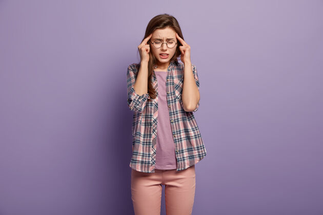 眼镜压力过大的过度劳累的女人总是把手指放在太阳穴上 患有头痛或偏头痛眼镜女性面部