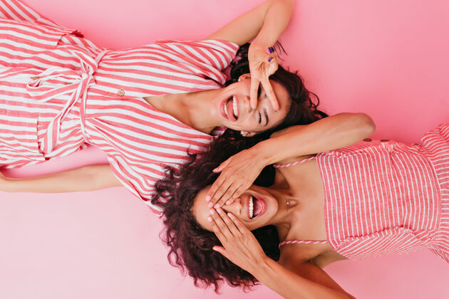 女性照片中的两个年轻女孩穿着漂亮的裙子和鲜艳的条纹太阳裙 微笑着闭上眼睛女人成人非洲