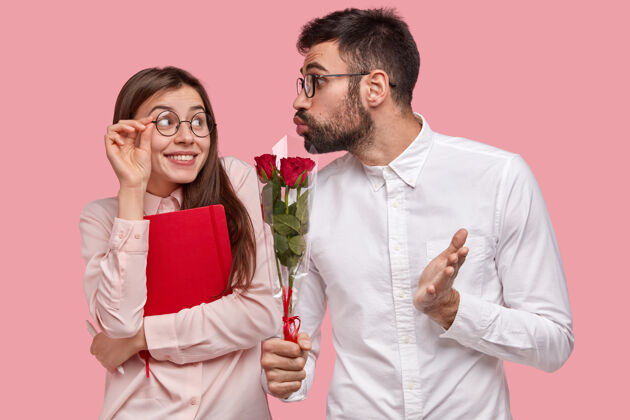 风格年轻多情的男人送一束红玫瑰给女朋友 皱起嘴唇亲吻学生已婚举行