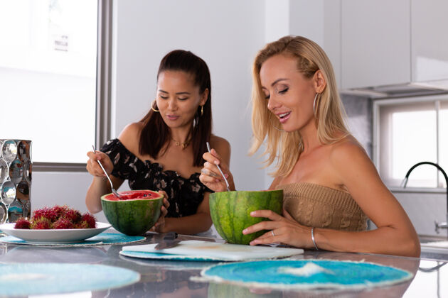 有机两个女朋友在厨房吃西瓜和红毛丹热带水果好吃饮食食物