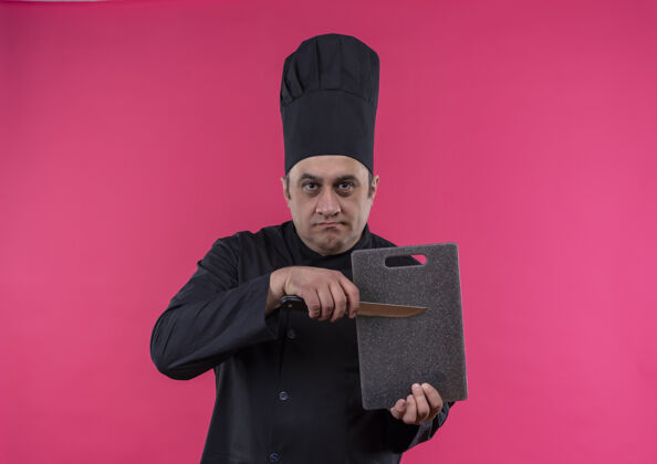 厨师严格的中年男厨师穿着厨师制服手持砧板和刀制服严刀