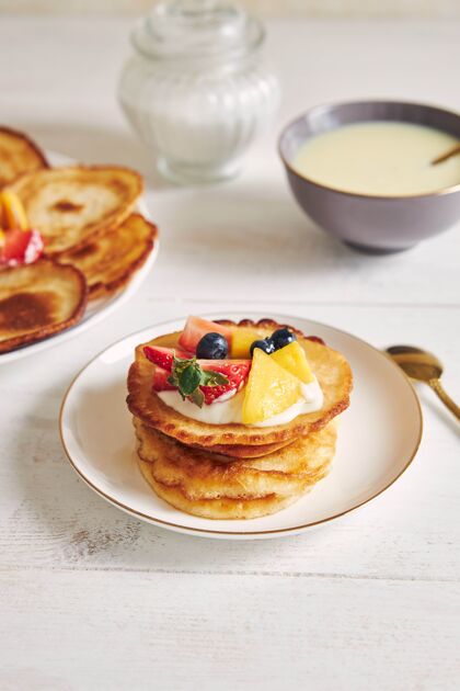 餐垂直拍摄美味的煎饼与水果上的早餐甜点咖啡馆风格
