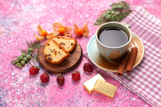 前面前视图美味的蛋糕切片新鲜的红色草莓一杯茶和肉桂在粉红色的办公桌上美味杯子草莓
