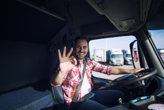 卡车卡车司机很喜欢他的工作 坐在卡车车厢里的时候还表现出良好的手势公路微笑集装箱