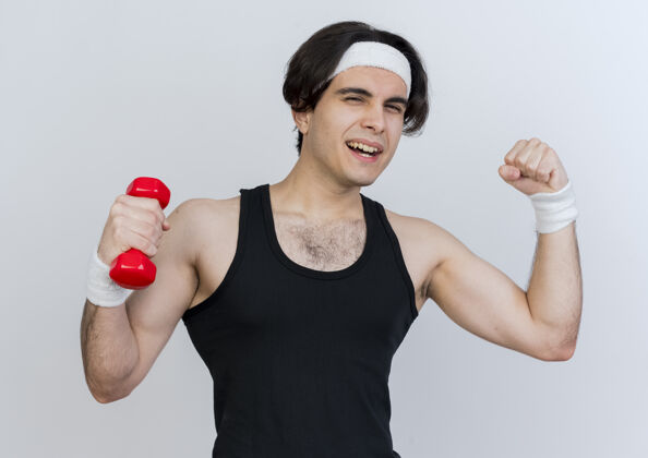 拳头年轻的运动型男子穿着运动服 戴着头巾 举着哑铃 拳头露出二头肌工作展示穿着