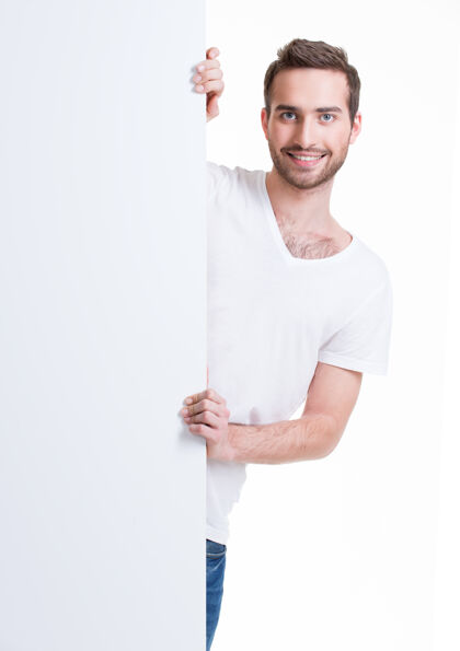 男快乐的年轻人从空白的横幅上望出去-孤立的白色广告牌男广告牌