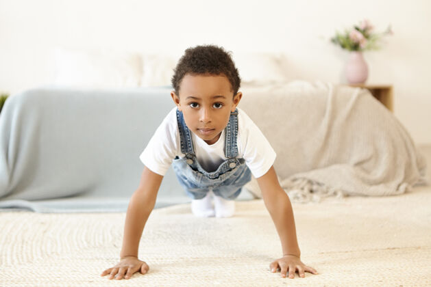 孩子室内拍摄的自律的非洲裔美国黑人男生锻炼柔韧性健身手臂