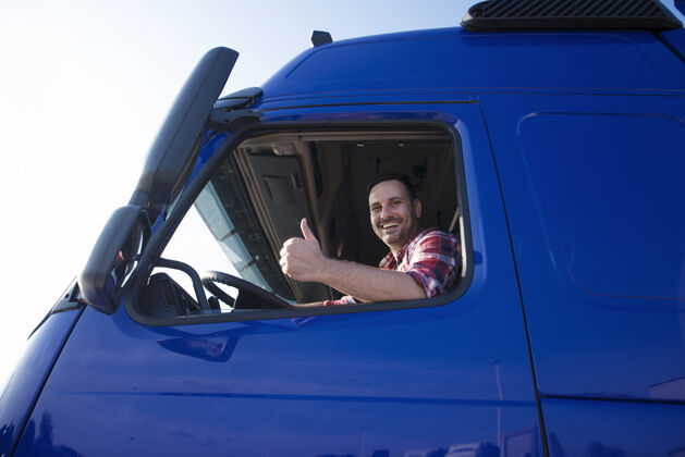 车辆卡车司机从驾驶室窗户向上竖起大拇指拖车男性卡车